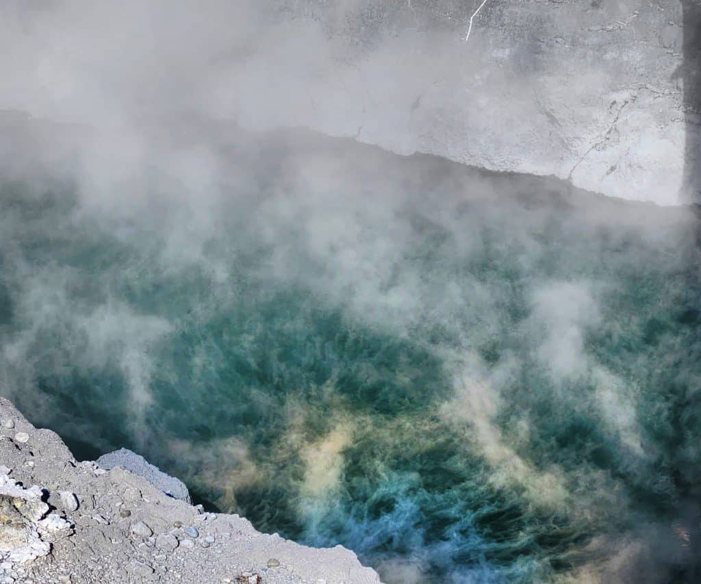 Steam rising from geothermal hot springs in Taranaki, showcasing natural geothermal energy and elements.